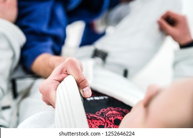 Close Up On Hand Holding A Grip On The Jiu Jitsu Judo Gi While Drilling The Technique  In Training