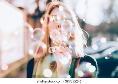 Close up on the hand of young beautiful woman blowing bubble soap - ethereal, joy, happiness concept - Powered by Shutterstock