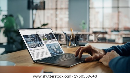 Close up on Hands of Caucasian Man Using Laptop Computer for Reading Latest News. Freelance Male is Doing Financial Market Analysis and Report for Clients and Employer in Cozy Creative Living Room.