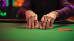 Close Up On Hands Of Professional Poker Dealer Doing A Riffle Shuffle Of Playing Cards Before High Stakes Game In Luxurious Casino. Anonymous Croupier Shuffling Deck Before Poker Tournament.
