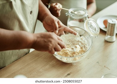 Close up on hands of senior Black woman stirring baking powder and eggs in glass bowl for making pancakes cooking together with granddaughter on wooden kitchen counter, copy space - Powered by Shutterstock