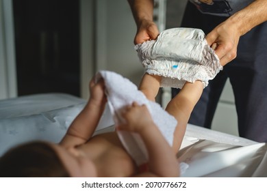 Close Up On Hands Of Unknown Caucasian Man Father Changing Diapers Of His Small Baby Son Or Daughter Boy Or Girl Selective Focus Copy Space Fatherhood And Parenthood Concept