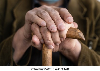 Close Up On Hands Of Unknown Old Caucasian Man Pensioner Senior Holding Cane Walking Stick While Sitting And Waiting - Real People Old Age Senility Concept Copy Space