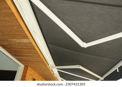 Close up on holders of automatic sliding canopy retractable roof system, patio awning for sunshade of a house. 