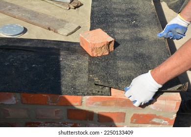 Close up on house foundation wall construction with builder contactor laying waterproofing membrane. House foundation waterprofing. - Shutterstock ID 2250133409