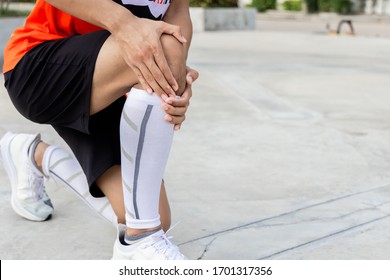 Close up on knee Injury. The man use hands hold on his knee whil