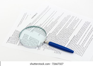 Close up on a legal contract with a magnifying glass