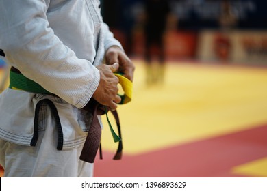 Close Up On Midsection Of A BJJ Jiu-jitsu Brazilian Jiujitsu Fighter Brown Belt In A White Gi Kimono Waiting For The Fight At The Tournament