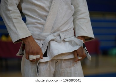 Close Up On Midsection Of A BJJ Jiu-jitsu Brazilian Jiujitsu Fighter White Belt Waiting For The Fight At The Tournament