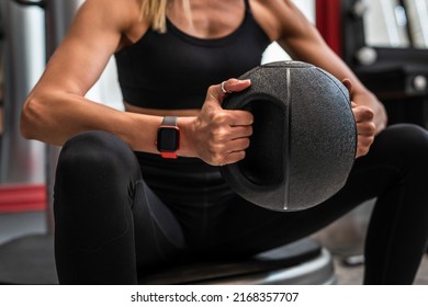 Close Up On Midsection Of Unknown Caucasian Woman Female Athlete Hands Holding Black Medicine Heavy Ball For Training Exercise While Sitting Taking A Brake Copy Space