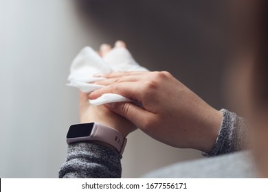 Close up on midsection of young caucasian woman hands wiping using white alcohol tissue cleaning napkin disinfection from virus and bacteria in day at home or office high angle view - Shutterstock ID 1677556171