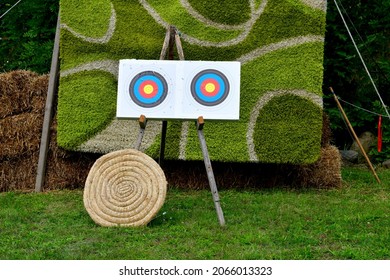 A close up on a modern target and one made out of wicker being used on a shooting range for bow and crossbow practice seen on an empty field covered with grass on a sunny summer day in Poland