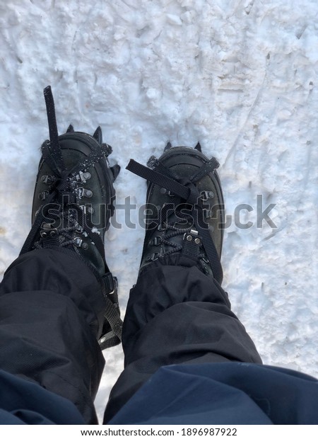 Close up on mountain boots with crampons.\
Climber ready to go on the snow and frozen ice\

