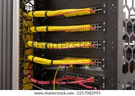 Close up on neat and tidy patched network cables, RJ45, connected to the switches and routers mounted on the rack in data centre, networking