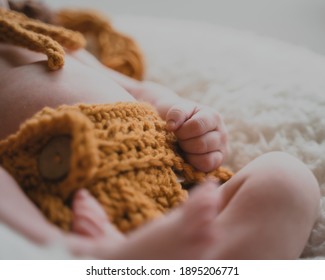 Close Up On Newborn Baby Hands And Fingers In Lion Onesie Costume In Natural Light