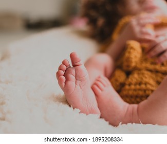 Close Up On Newborn Baby Hands And Fingers In Lion Onesie Costume In Natural Light