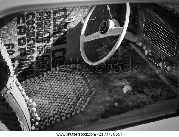 Close up on old vintage car steering wheel and\
cockpit. Retro styled image of an old car radio inside classic\
car-August 17, 2022-Vancouver BC Canada. Nobody, travel photo,\
selective focus