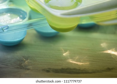 Close Up On A Part Of A Spherical Shape Ice Cube Bucket, Placed On A Blurred Wooden Surface Sprayed With Light Reflections Giving An Abstract Impression Of Freshness