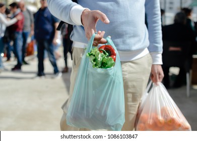 Close up on person buyer hold groceries in bags. Buy sell vegetables. Healthy wellbeing lifestyle background