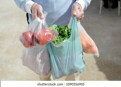 Close up on person buyer hold groceries in bags. Buy sell vegetables. Healthy wellbeing lifestyle background