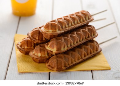 Close up on a pile of corn dogs. Freshly fried snacks served with a cup of tea on wooden table.