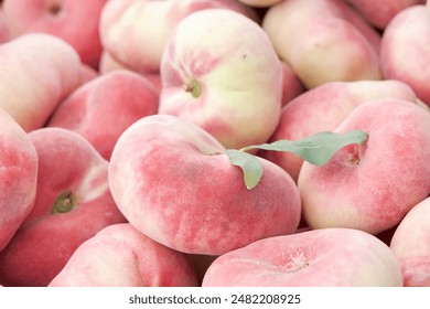 Close up on pile of fresh sweet Donut Peaches sale at farmers market.. View from above. - Powered by Shutterstock