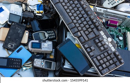 Close Up On Pile Of Mixed Electronic Waste, Old Broken Computer Parts And Cell Phones