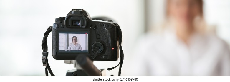 Close up on professional dslr camera filming new videovlog woman vlogger. Business coach gives lecture, live training on-line, commercial ad concept. Horizontal photo banner for website header design - Powered by Shutterstock