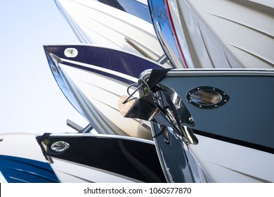 Close up on a rack of modern speedboats for sale, with pointed fiberglass hulls and bows, at a maritime storage boat yard