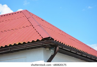 Close Up On Red Roofing Construction House With Roof Gutter System.