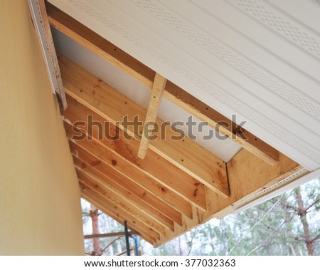 Close up on Roofing Construction. Soffit and Fascia Installation. is Usually Constructed of Vinyl, Wood or Aluminum and is Installed on the Underside of Roof Overhangs and Eaves.