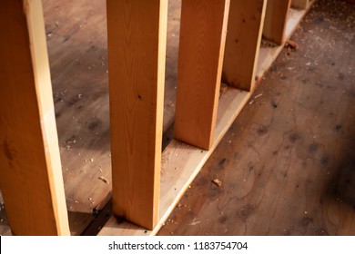 Close up on a row of timber wall studs, with exposed wood framing, in a home construction background, with space for text on the right 
