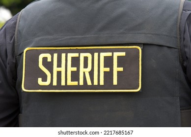 Close Up On Sheriff Letters On Back Of Flack Jacket.