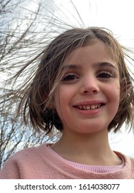 Close Up On A Smiling Young Girl With Static Electricity Hair.