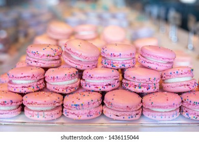 Close up on a stack of pink sprinkle macaroon cookies, in a gourmet french bakery