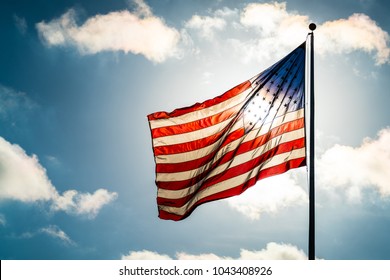 Close Up On Stars And Stripes Waving In The Breeze The National American Flag Illuminated Back Lit By Sun. United States Flag Waving In The Wind On A Dramatic Sky Day