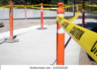 Close up on a strand of caution tape on a bollard cone, at a construction work site, with space for text on the left - Shutterstock ID 1153165520
