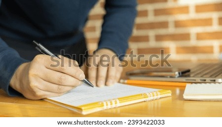 close up on teacher man hand using pen to writing schedule on calendar 2024 to make appointment or manage timetable each day at school for work lifestyle concept	