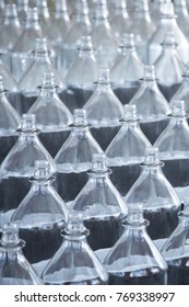 Close Up On Tiered Rows Of Clear Glass Bottles For A Ring Toss Game At A Carnival Boardwalk