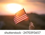 Close up on USA flag in a hand of a persone. Independence Day or traveling in America concept.