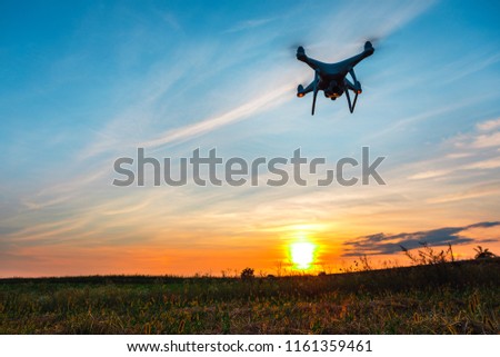 Close up on white drone camera. Drone quadcopter in flight