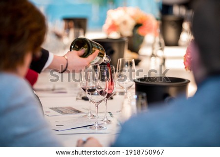 close up on a wine glasses, bottle and red wine being poured Сток-фото © 