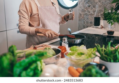 Close up on woman hands  preparing dinner in the kitchen. One elderly female alone cooking. Real lifestyle person testing taste and cook preparation. - Powered by Shutterstock