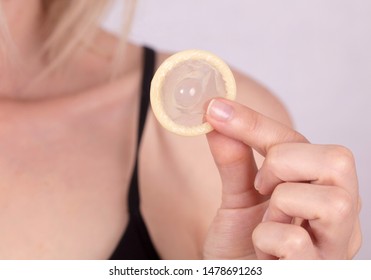 Close Up On Woman Holding A Condom. Prevention Of Sexually Transmitted Diseases. Health Care And STD Prevention Concept.