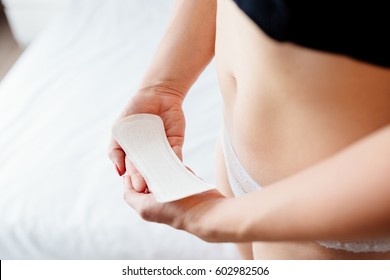 Close up on woman holding white sanitary pad in hand. Woman period