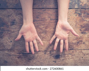 Close up on a woman showing her palms at a wooden table - Shutterstock ID 272600861