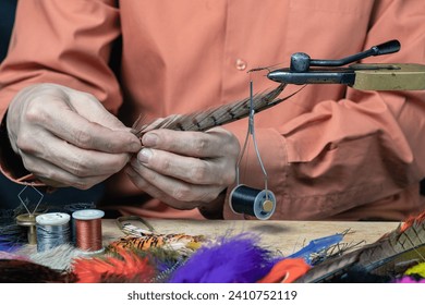 Close up on young man's hands tying a fly for fishing - Powered by Shutterstock