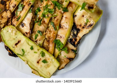 Close Up On Zucchini Courgette Summer Squash Salad With Garlic And Oil On A White Plate On The Table