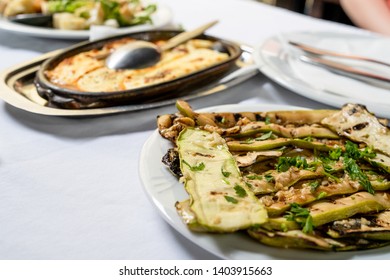 Close Up On Zucchini Courgette Summer Squash Salad With Garlic And Oil On A White Plate On The Table