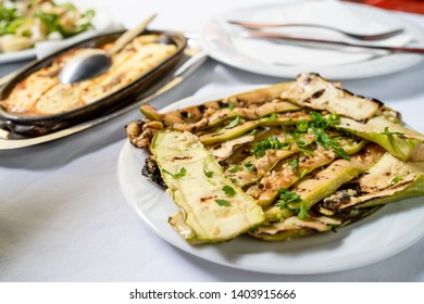 Close Up On Zucchini Courgette Summer Squash Salad With Garlic And Oil On A White Plate On The Table